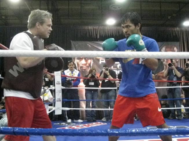 Manny Pacquiao moves in on his trainer, Freddie Roach, during today's open workout.
