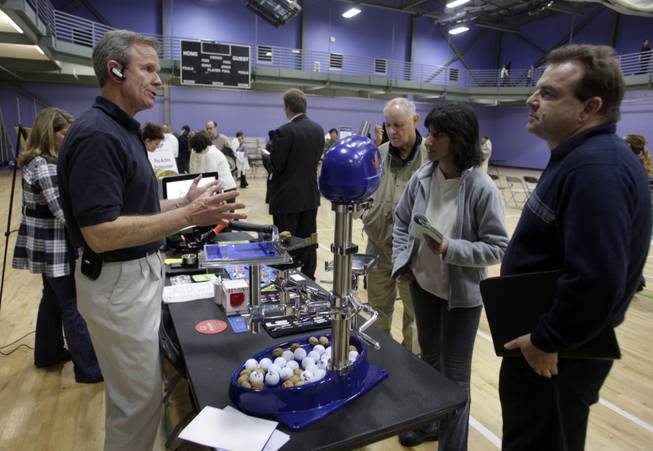 Golden advice: Bill Bokelmann, left, owner of Maxx Promotions, talks with Boyd Irons, right, and his wife Neeshima during the Henderson Entrepreneur Fair last month.  