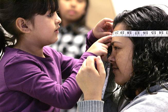 Melissa Alcantar, 6, measures her mother Erika Alcantar's head as a math exercise during math night at Herron Elementary School in North Las Vegas Wednesday, March 24, 2010.