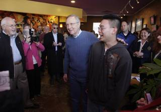 Senate Majority Leader Harry Reid (D-Nev.) shares the spotlight with Benjamin Syang, 17, who was recently accepted into the Air Force Academy, during a campaign stop at the 88 Cups Coffee & Tea shop in Minden, Nev., Tuesday, April 6, 2010. 