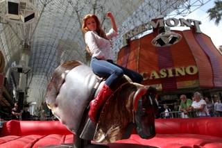 Angelica Bridges rides during the PBR sponsored mechanical Bull Riding Media Showdown at Fremont Street in Las Vegas.