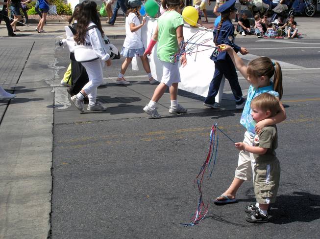 Marley Spielberg, 4, waves to people in the Henderson Heritage Parade with her brother Madden, 1.