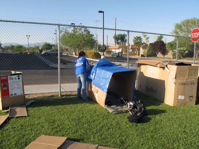 Renea Valdez sets up the cardboard box she will sleep in Saturday night as part of a Family Promise fundraiser.
