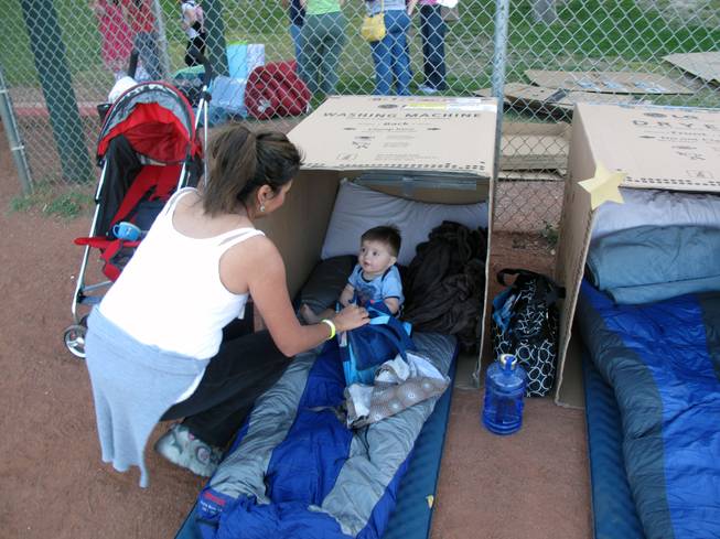 Rene Barton puts her 9-month-old son, Matthew, in the cardboard box the two will call home for one night to learn what it feels like to he homeless.