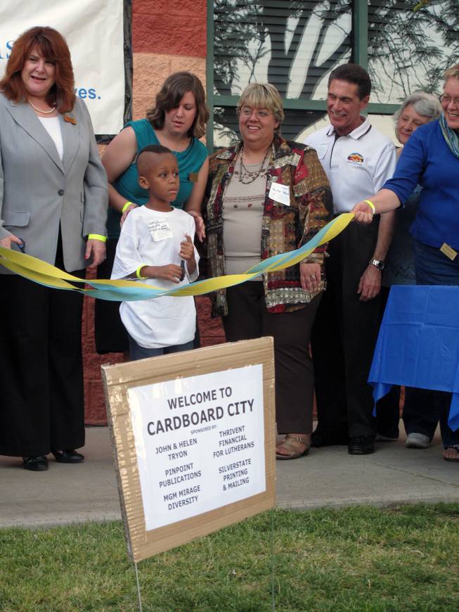 James Kelly, age 7, prepares to cut the ribbon to open Cardboard City, where he will be mayor for the night, at a fundraiser for Family Promise.