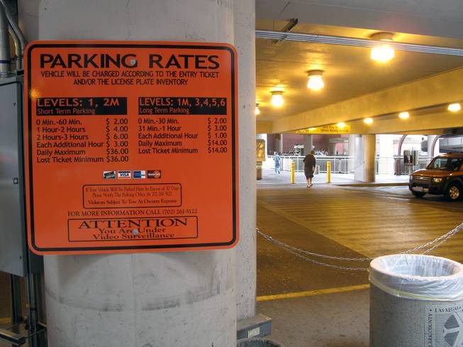 A sign near the passenger pickup area shows the fees to park at McCarran International Airport's parking lots with the new Express Exit pay system.