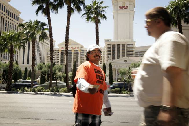 A handbiller outside the Flamingo just north of Flamingo Road on the Strip passes out cards for an escort service in May 2010. 