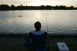 David Rivero watches the evening sky while fishing Thursday at Sunset Park .