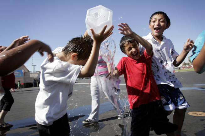 First graders Angel Lopez, red shirt, and Mario Sotelo, right, play a game with a container of water during field day at Fay Herron Elementary School in North Las Vegas Thursday, May 20, 2010.