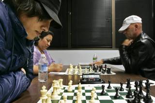 Oswaldo Rodriguez ponders his options during a game at a gathering of the Clark County Chess Club Thrusday, May 20, 2010. Playing in the background are Christine Mariano, an international chess master, and Lynn Parker.