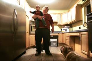 Jack Rode holds his two-year-old grandson Latreovion Mendoza after putting away groceries in the kitchen of his Las Vegas home Wednesday, May 26, 2010.  The mother of Rode's children and his 28 year companion Donna Wendt died March 13, 2009 after an accident at Sunrise Hospital Medical Center. Her windpipe was torn open when they inserted a breathing tube, causing oxygen to be pumped into her body instead of her lungs. The torn windpipe was not immediately detected, allowing air to be pumped into her chest cavity for about 24 hours. Just before her death, they had finished remodeling their kitchen to be accessible for Wendt, who was wheelchair-bound, with low countertops, a raised dishwasher and oven, and pull out drawers and cabinets for easy access.