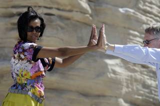 First lady Michelle Obama and Senate Majority Leader Harry Reid stretch during an exercise activity Tuesday at the Red Rock Canyon National Conservation Area. Obama, Reid Assistant Secretary of the Interior Rhea Suh kicked off the national 
