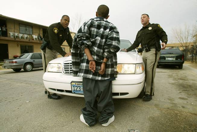 Detective Ramon Denby and detective Steve Morris of Metro's gang crimes section talk to a 13-year-old who claims to be a member of the North Hollywood Pee Wees gang after stopping him for driving a car without a license February 17th 2004.