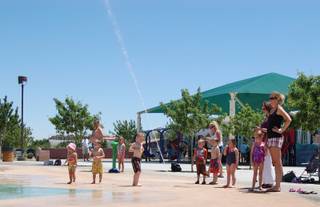 In this June 2010 photo, parents and children enjoy the splash pad at Paseo Vista Park in Henderson.
