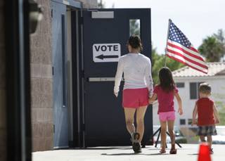 A woman and her children head to a polling place at Greenspun Middle School Tuesday, June 8, 2010.