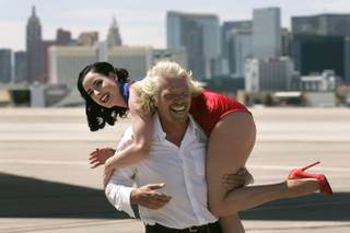 Virgin Airlines President Richard Branson carries burlesque star Dita Von Teese on his shoulders during a media event to mark the 10th anniversary of Virgin Atlantic's London to Las Vegas route Tuesday, June 15, 2010.