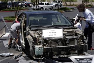 Boys look inside a stripped 2007 Toyota Camry during a 