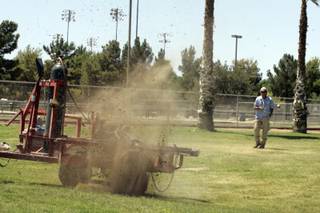 Herman Britz, a park maintenance worker, uses a Rodenator to blow up gopher holes Tuesday in Sunset Park.