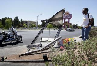 Torri Jasper looks over a bus shelter after an accident on Rancho Drive just north of Lake Mead Boulevard Monday, June 21, 2010. The driver of a northbound pickup truck ran the red light, colliding with another vehicle before hitting the shelter. The driver of the truck, a person waiting at the bus shelter and the driver of another vehicle were transported to the hospital, police said.