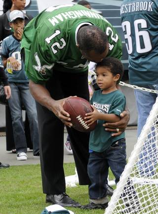 This photo made Sept. 27, 2009, shows former Philadelphia Eagles football player Randall Cunningham giving his son, Christian, a football during halftime of an NFL football game, in Philadelphia. The 2-year-old son of former NFL star quarterback Randall Cunningham has died in what authorities on Wednesday, June 30, 2010, called an apparent backyard hot tub accident, in Las Vegas. The Clark County coroner's office identified the child as Christian Cunningham, and said the cause of death was pending.