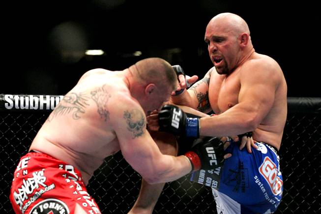 Shane Carwin catches Brock Lesnar with a knee during their heavyweight title fight Saturday at UFC 116. Lesnar won with a second-round submission.