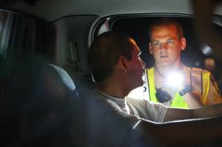 An unidentified driver complies with commands while being examined by Metro Police Officer Eric Hutchason during a vehicle stop Friday, July 2, 2010, at a DUI checkpoint on Nellis Boulevard south of East Lake Mead Boulevard.
