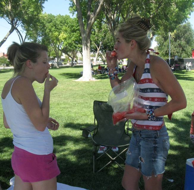 From left, Betsy Lockwood, 21, and Katelyn Conrad, 20, eat watermelon Saturday at Memorial Park during Boulder City's 62nd annual Damboree Celebration.