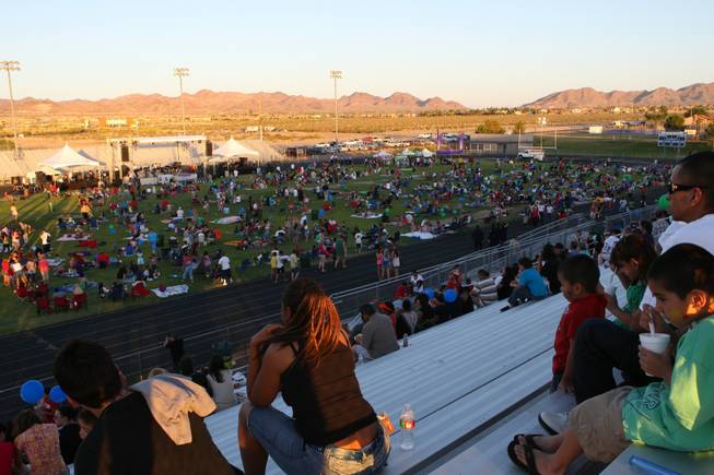 Thousands of spectators gather on the football field in anticipation of the fireworks display during Henderson's Fourth of July celebration Sunday night at Basic High School.