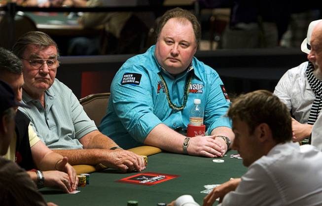 Poker professional Greg Raymer, center, competes during the first day of the 41st annual World Series of Poker no-limit Texas Hold 'em main event Monday, July 5, 2010. Raymer won the main event in 2004. It's expected that 6,000 to 7,000 players will pay the $10,000 buy-in to enter the tournament, officials said. 