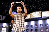 Daniel Alaei raises the gold bracelet he won for finishing first in the $10,000 Pot Limit Omaha tournament at the World Series of Poker.