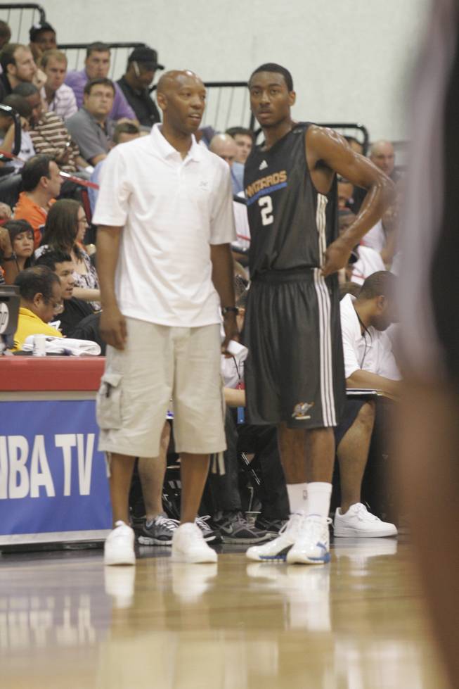 Washington guard John Wall, right, talks during a break in the action on Sunday with Wizards coach Sam Cassell. Wall, the top pick in last month's NBA draft, led the Wizards to an 84-79 victory over the Golden State Warriors in his team's Summer League opener at the Cox Pavilion with 24 points and eight assists.