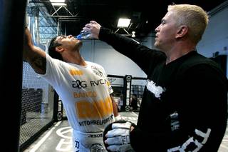 Brazilian middleweight Vitor Belfort gets a drink from trainer Shawn Tompkins after a workout at TapouT Wednesday, July 14, 2010.