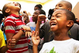Benjamin Horsford, from left in red stripes, Gregory Oliver, in grey, and Bryson Horsford, front right, sing and dance during the morning Harambee session at Rainbow Dreams Academy in Las Vegas Thursday, July 22, 2010.