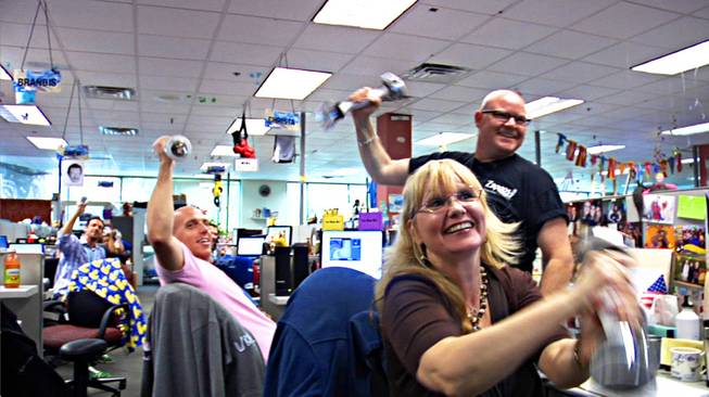 Zappos culture guide Jon Wolske and fellow Zappos employees welcome a tour group with a choreographed weight-lifting routine to the tune of Eye of the Tiger in the Zappos office building in Henderson on Thursday, July 23, 2010. Different Zappos departments regularly compete for the best tour-welcoming cheer or performance.  