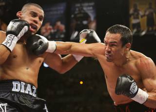Juan Diaz, left, of Houston, Texas takes a punch from Juan Manuel Marquez of Mexico City during the WBA/WBO lightweight title fight at the Mandalay Bay Events Center in Las Vegas on July 31, 2010.