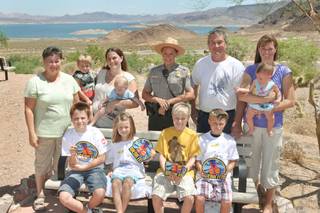 Members of the Torrance family, of Las Vegas, take a picture with Ranger Laura Anderson, center, who helped them after their boat sank Saturday on Lake Mohave.