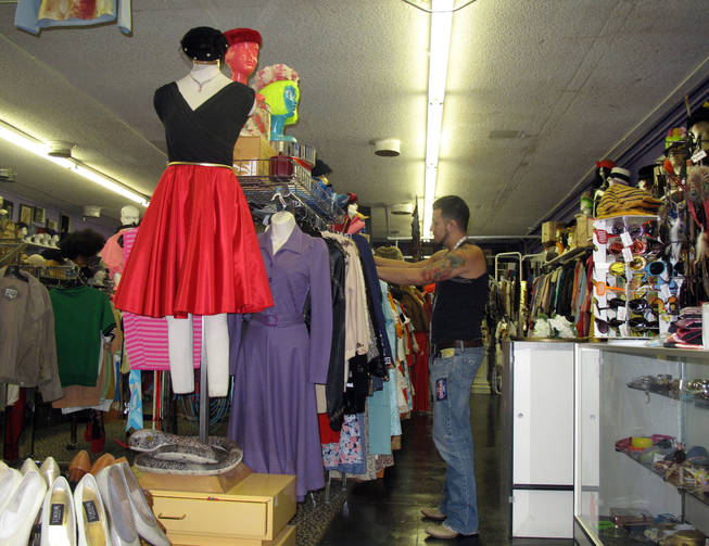 Angel Gonzales, the in-house designer at The Attic, arranged merchandise at the vintage clothing store's new location, 1025 South Main St. The Attic's former building across the street sustained damage from a July 11 NV Energy substation explosion.