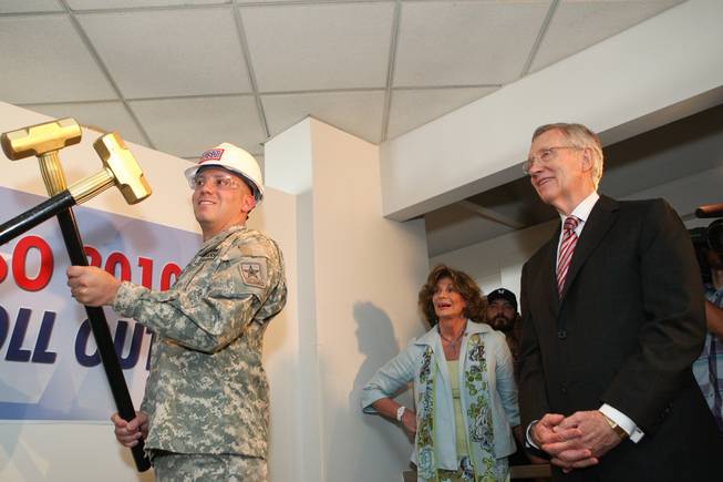 U.S. Sen. Harry Reid and U.S. Rep. Shelley Berkley (both D-Nev.) watch on as Sgt. Jason Schwartz crosses a gold sledge hammer prior to ceremoniously hitting a wall inside the new USO lounge during the groundbreaking ceremony in Terminal 1 at McCarran International Airport on Wednesday, August 18, 2010.