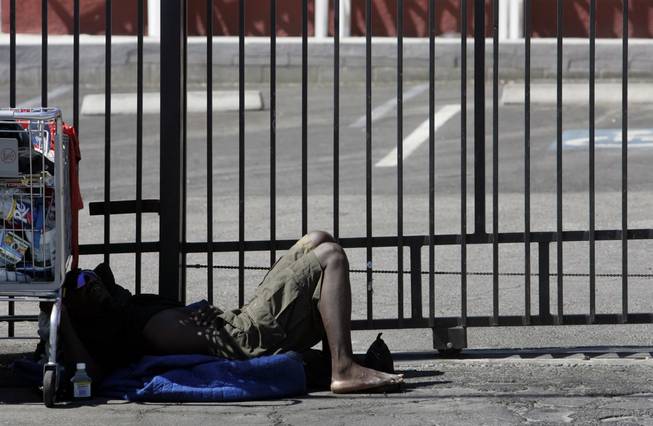 A homeless man takes a nap on Foremaster Lane last summer. Homelessness is a factor in the redevelopment of downtown Las Vegas.