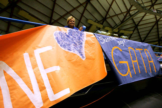 Bishop Gorman cheer coach Donna White hangs a banner Saturday in the J. Lawrence Walkup Skydome at Northern Arizona University in Flagstaff before Gorman's game against Hamilton High of Chandler, Ariz., in the Sollenberger Classic.