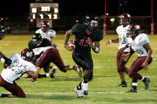 Las Vegas quarterback Hassan Henderson finds a hole for a touchdown against Cimarron-Memorial on Thursday during the first high school football game of the season. Las Vegas won the game 34-15.