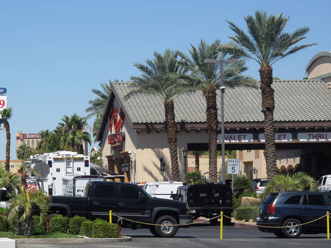 Police clean up their equipment Saturday morning after responding to a man who claimed to have a bomb at Arizona Charlie's Boulder Hotel and Casino. The bomb ended up being a hoax, police said.