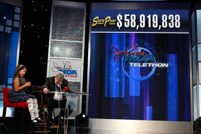 Jerry Lewis and 2010 MDA ambassador Abbey Umali celebrate the final tally of $58,919,838 as it appears on the tote board Monday afternoon during the final hour of the 45th Annual Jerry Lewis MDA Labor Day Telethon at the South Point.