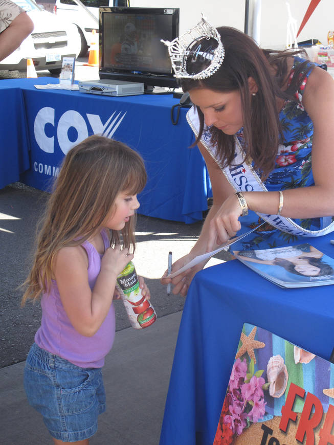 Miss Hawaii 2010 Jalee Fuselier autographs a picture for Lizzy McAffee, 4, during the Prince Jonah Ho'olaule'a Pacific Islands Festival in Henderson on Sunday. Fuselier will be back in Las Vegas in January to compete in the Miss America contest.

