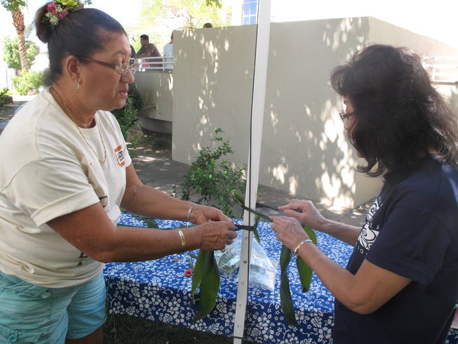 Maxeen Shea, left, teaches Virginia Keeler, right, how to make a ti-leaf lei at the Prince Jonah Ho'olaule'a Pacific Islands Festival on Sunday.