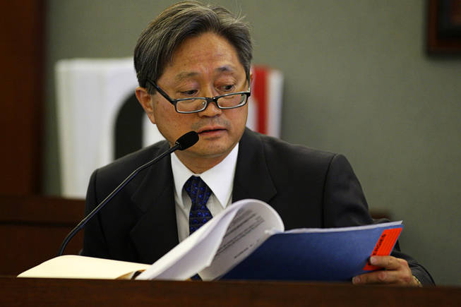 Dr. Daniel Kim, one of Erik Scott's physicians, looks through medical records during a coroner's inquest at the Regional Justice Center Wednesday, September 22, 2010. 