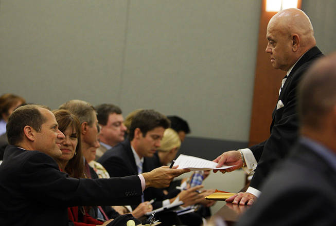 Ross Goodman, attorney for the Scott family, hands a question to Clark County Coroner Mike Murphy during a coroner's inquest at the Regional Justice Center Wednesday, September 22, 2010. 