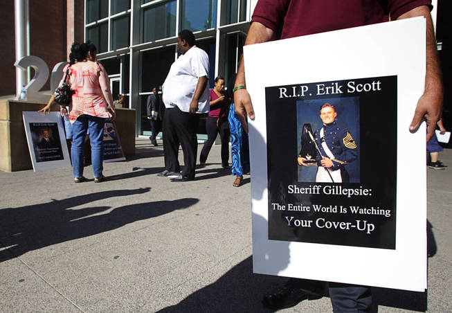 Dustin Deguevara holds a sign in front of the Regional Justice Center before a coroner's inquest into the shooting of Erik Scott Wednesday, September 22, 2010. Scott was shot and killed by Metro Police Officers at the Summerlin Costco on July 10. Deguevara said he is best friends with Erik's younger brother. 