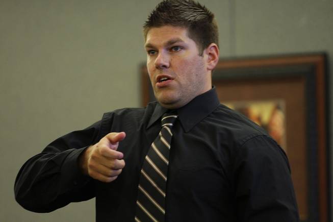 Shai Lierley, a Costco loss prevention supervisor, demonstrates how Erik Scott brought his gun on an officer as he testifies during a coroner's inquest at the Regional Justice Center Thursday, September 23, 2010. 