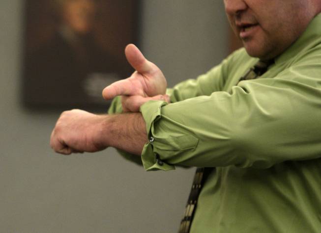 Steven Novotny demonstrates how Erik Scott pointed a gun at him and his dog as he testifies during a coroner's inquest at the Regional Justice Center Thursday, September 23, 2010. Novotny said the event occurred after his dog got loose and bit Scott.